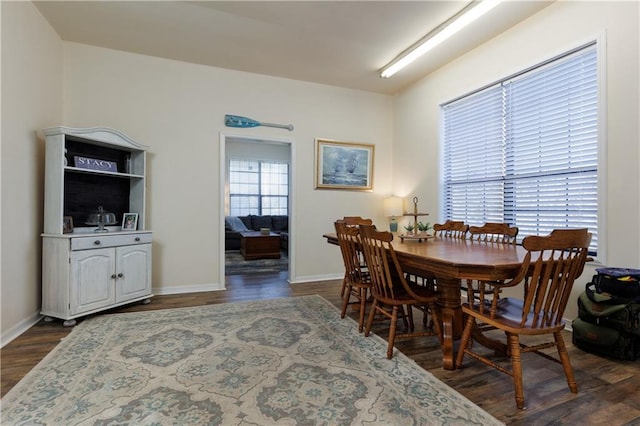 dining space with a healthy amount of sunlight, baseboards, and dark wood-style flooring