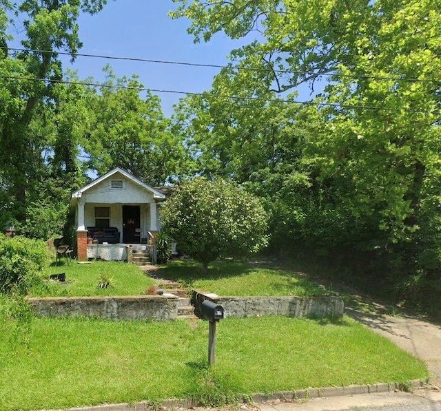 view of front of property with covered porch and a front yard