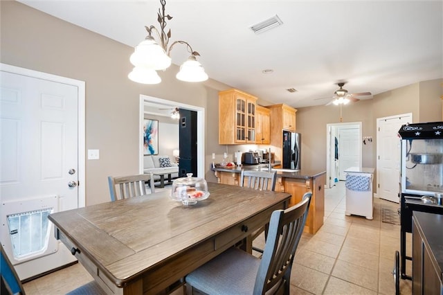 tiled dining room featuring ceiling fan with notable chandelier