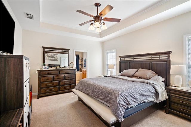 carpeted bedroom with ceiling fan and a tray ceiling