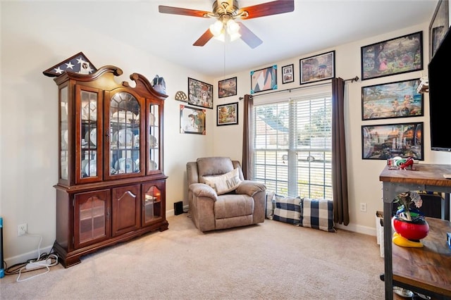 living area with ceiling fan and light colored carpet