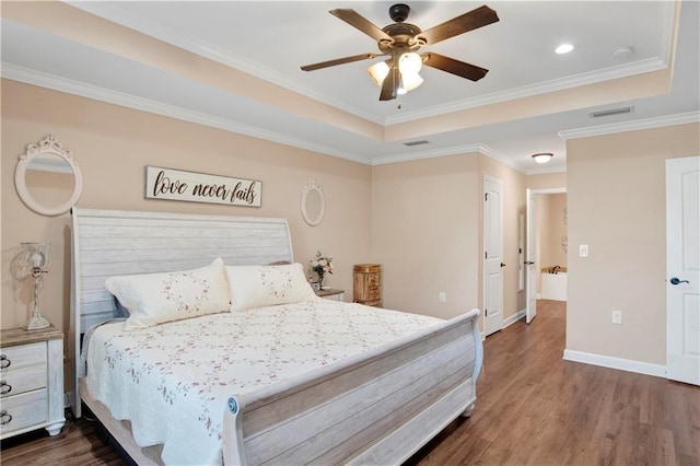 bedroom with ornamental molding, a tray ceiling, ceiling fan, and dark wood-type flooring