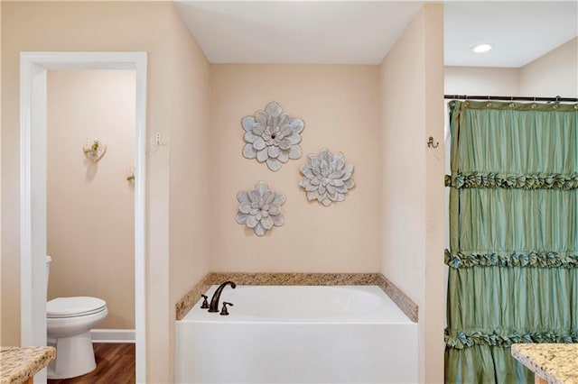 bathroom with hardwood / wood-style floors, a bathtub, toilet, and vanity