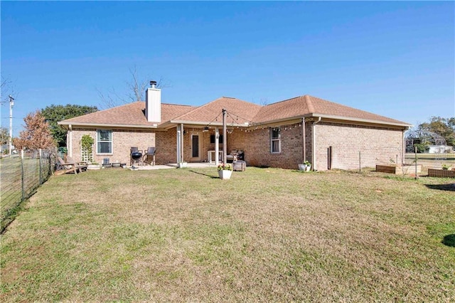 rear view of house with a yard and a patio