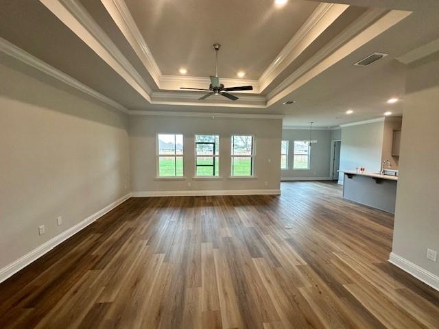 kitchen with a center island with sink, stainless steel appliances, ornamental molding, white cabinetry, and ceiling fan