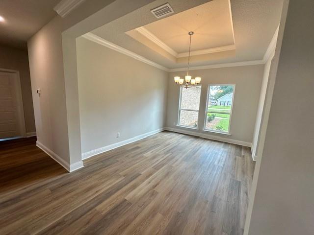 spare room featuring crown molding, ceiling fan, a raised ceiling, and wood-type flooring