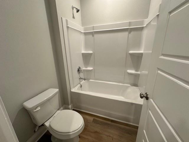 bathroom with shower / bathing tub combination, toilet, and hardwood / wood-style floors