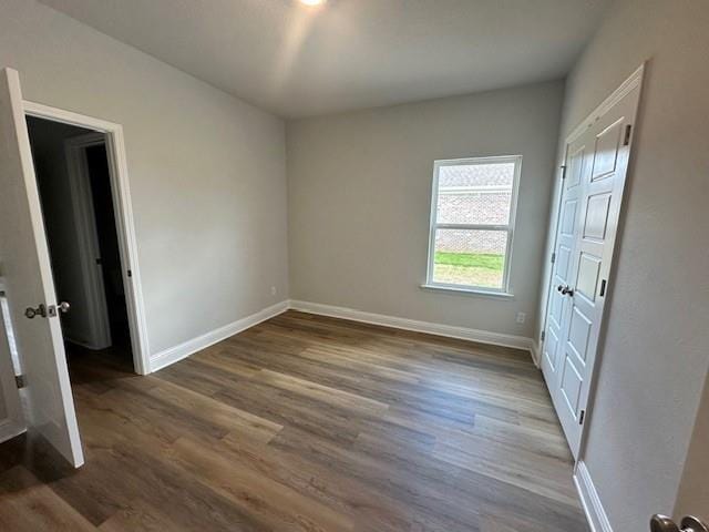 unfurnished room featuring dark wood-type flooring