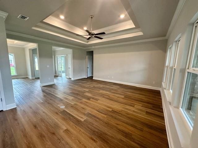 spare room featuring crown molding, a raised ceiling, dark hardwood / wood-style flooring, and ceiling fan