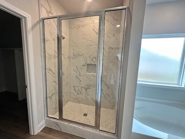 bathroom with hardwood / wood-style floors, plenty of natural light, and independent shower and bath