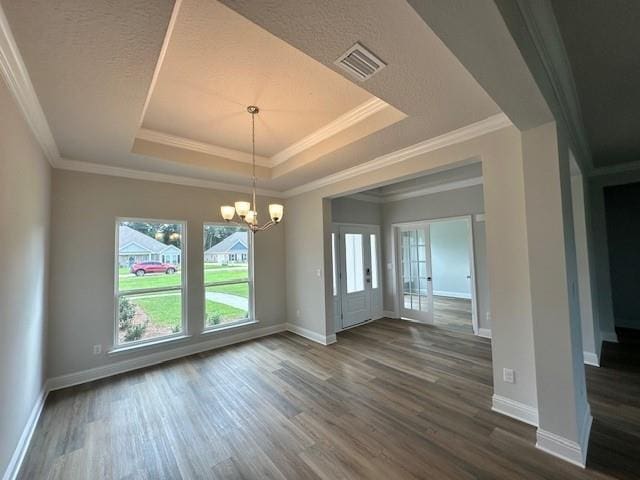 unfurnished dining area with a tray ceiling, dark wood-type flooring, ornamental molding, and an inviting chandelier