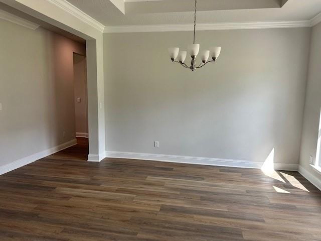 entrance foyer with ornamental molding, an inviting chandelier, light wood-type flooring, and a tray ceiling