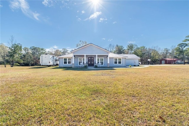 rear view of property with covered porch and a yard