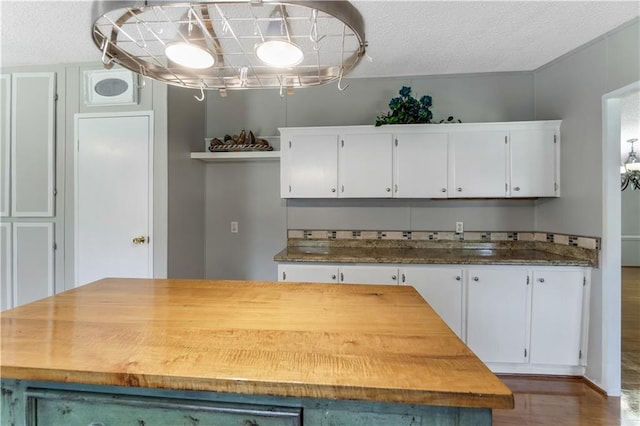 3628 Jarvis Ln, Semmes, AL 36575 - kitchen featuring white cabinets, a center island, a textured ceiling, and dark wood-type flooring