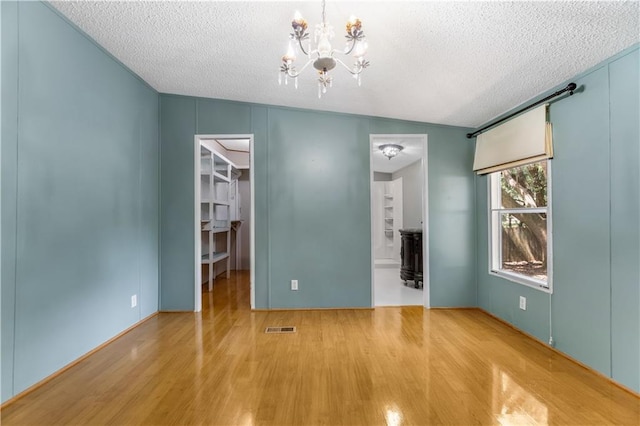 3628 Jarvis Ln, Semmes, AL 36575 - unfurnished bedroom featuring wood finished floors, a textured ceiling, a chandelier, a walk in closet, and ensuite bath