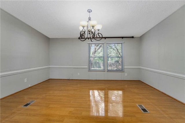 3628 Jarvis Ln, Semmes, AL 36575 - spare room featuring a chandelier, wood finished floors, and a textured ceiling