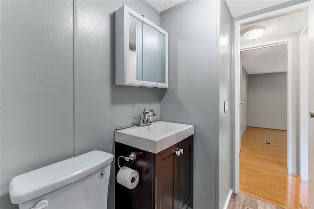 3628 Jarvis Ln, Semmes, AL 36575 - half bathroom with toilet, wood finished floors, vanity, and a textured ceiling
