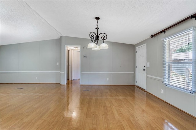 3628 Jarvis Ln, Semmes, AL 36575 - unfurnished dining area featuring a textured ceiling, a chandelier, light wood-style flooring, and vaulted ceiling