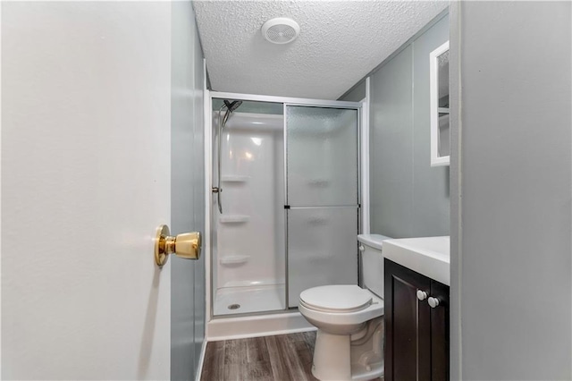 3628 Jarvis Ln, Semmes, AL 36575 - bathroom featuring wood finished floors, a shower stall, a textured ceiling, vanity, and toilet