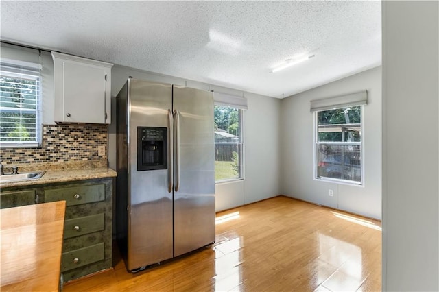 3628 Jarvis Ln, Semmes, AL 36575 - kitchen with stainless steel fridge with ice dispenser, a textured ceiling, light wood-style floors, light countertops, and tasteful backsplash