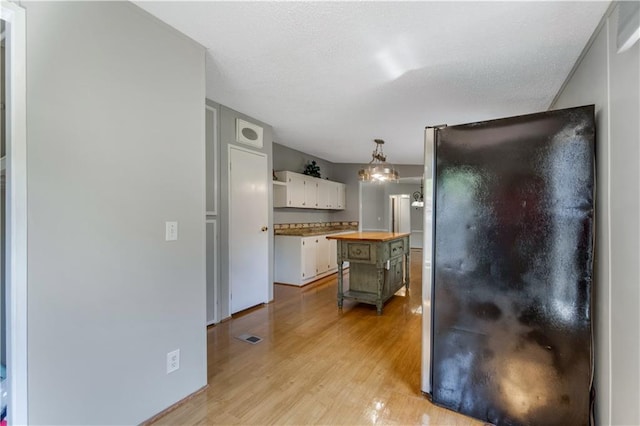 3628 Jarvis Ln, Semmes, AL 36575 - kitchen with wooden counters, freestanding refrigerator, light wood-type flooring, white cabinets, and open shelves
