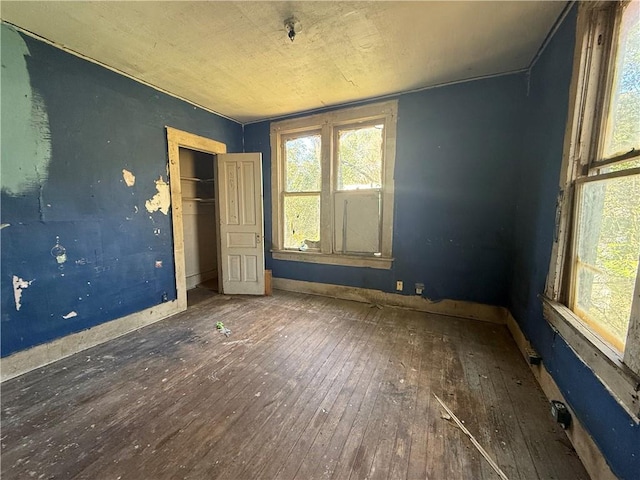 unfurnished bedroom featuring dark hardwood / wood-style floors and a closet