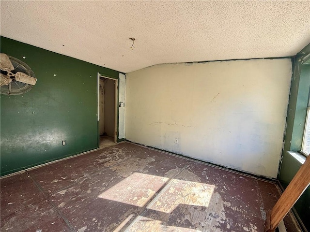 spare room with a textured ceiling and lofted ceiling