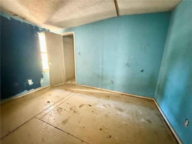 unfurnished room with a textured ceiling