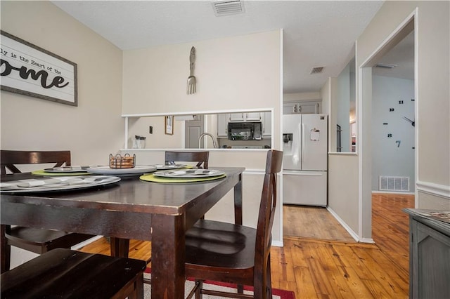 dining space with light wood-style flooring and baseboards