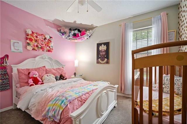 bedroom featuring carpet, a textured ceiling, baseboards, and a ceiling fan