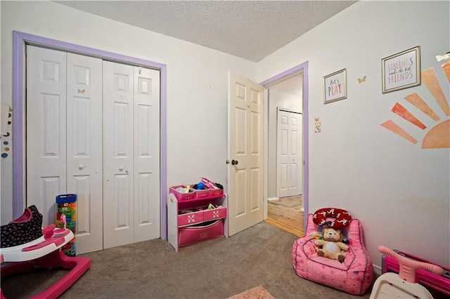 rec room featuring carpet floors and a textured ceiling