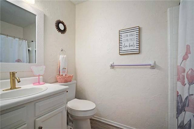 bathroom with wood finished floors, vanity, toilet, and a shower with curtain