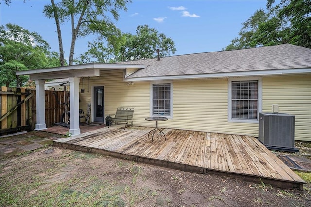 rear view of property with cooling unit, fence, a deck, and a shingled roof