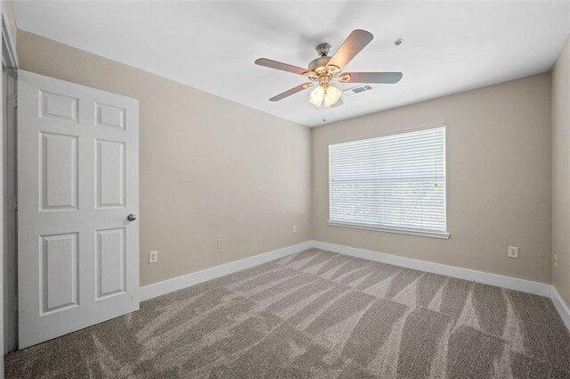 carpeted spare room with ceiling fan