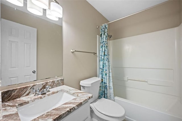 full bathroom featuring vanity, shower / bath combo with shower curtain, and toilet