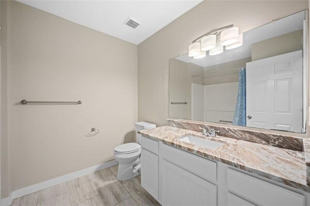1517 Regency Rd Unit 46, Gulf Shores, AL 36542 - bathroom with toilet, a shower with shower curtain, visible vents, baseboards, and vanity