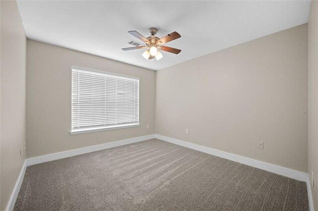 carpeted spare room featuring ceiling fan