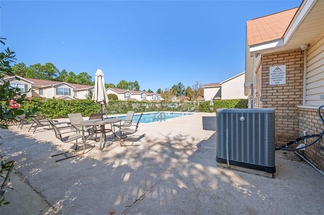 view of swimming pool with central air condition unit and a patio area