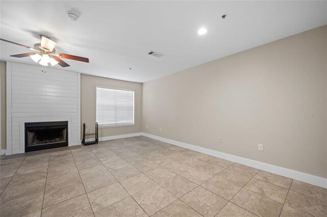 unfurnished living room with ceiling fan, light tile patterned floors, and a fireplace