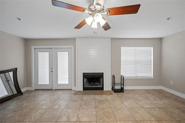 unfurnished living room featuring french doors, light tile patterned flooring, a fireplace, and ceiling fan