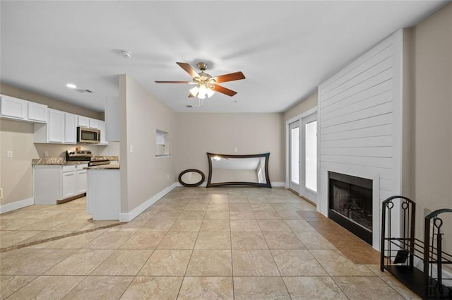 unfurnished living room with ceiling fan, light tile patterned floors, and a fireplace