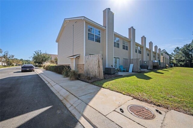 exterior space featuring central AC and a lawn