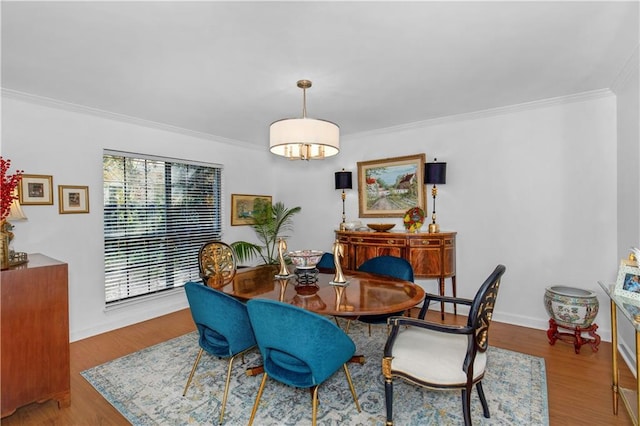 dining space with baseboards, ornamental molding, and light wood-style floors