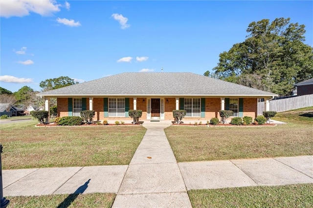 single story home featuring covered porch and a front yard