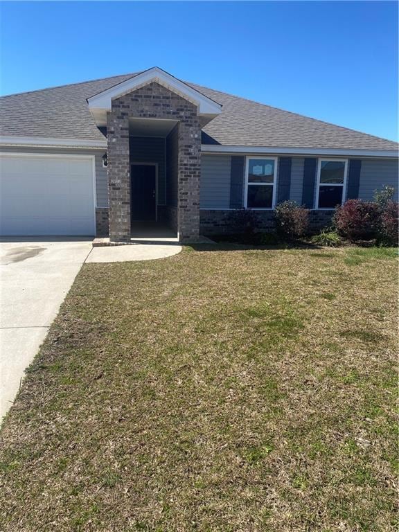 single story home with driveway, a shingled roof, an attached garage, a front yard, and brick siding