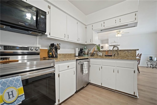 5554 Racine Ave, Mobile, AL 36618 - kitchen with stainless steel appliances, white cabinets, light wood-type flooring, a ceiling fan, and light stone counters