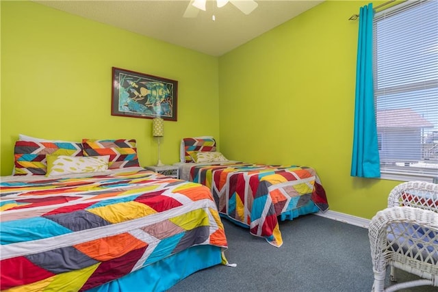 carpeted bedroom featuring baseboards and ceiling fan