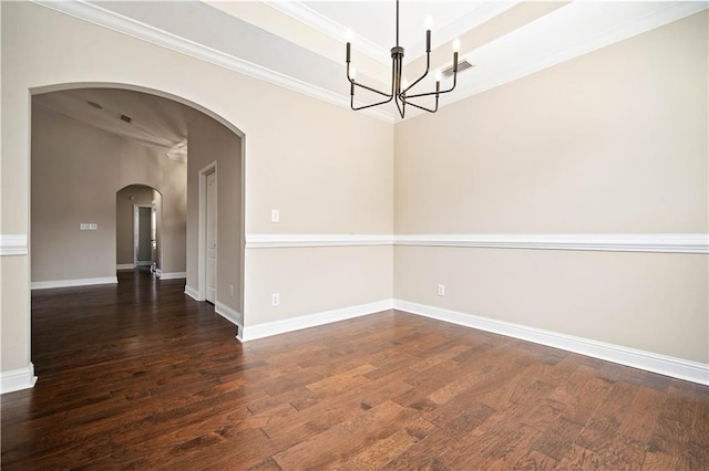 spare room featuring visible vents, dark wood-type flooring, ornamental molding, a tray ceiling, and an inviting chandelier