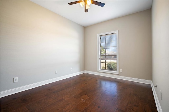 spare room with a ceiling fan, dark wood-style floors, and baseboards