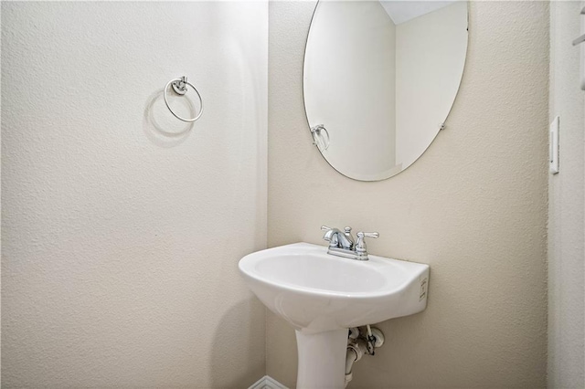 bathroom featuring a sink and a textured wall